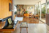 This built-in seating area backs a dividing wall that sets off the kitchen and faces a brick inlay fireplace.