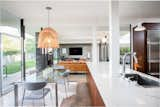 The kitchen overlooks the dining area, adding to the breezy flow of the public space. The home features polished concrete floors throughout.