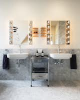 The bathroom features wall-mounted Duravit washbasins and custom shelves for eyeglasses. 