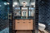 This bright bedroom has a monochromatic bathroom with a spacious walk-in shower that is covered in sleek subway tiles.  

