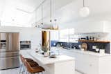 The once dim, cramped kitchen in this 1963 Eichler in San Jose, California, now features luxe vinyl tiling, white slab fronts from Semihandmade, and a dual-pane window, courtesy of Cathie Hong Interiors.