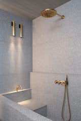 Terrazzo clads the shower and bath. All of the brass faucets in the apartment are from Vola.