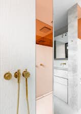 Peach-tinted glass in the shower is an unexpected accent, yet flows with the rest of the home. "The interior strikes a fine balance between energy and respite, boldness and refinement; an appealing and youthful space that is an expression of Tom’s lifestyle and arts practice," says Lynch.