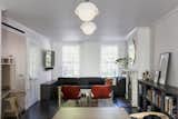 The living room received a Muuto Connect sofa, which was "notched into" the custom media cabinetry. The existing wood floors were refinished with an ebony satin stain with a charcoal tone.