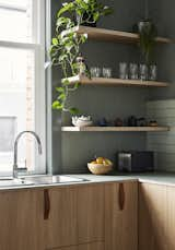 Simple leather pulls adorn the cabinet faces, while open shelves put everyday items within easy reach.