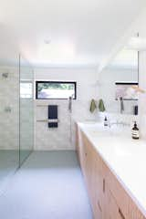 The Caesarstone and plywood vanity echoes the materials in the kitchen, as does the wall tile.