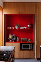 Bright red laminate shelves hold the family’s coffee supplies in a delightful reveal.