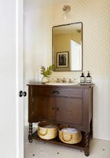 Small-scale hex floor tiles work better with the home’s vintage—as does the new wainscot and Swedish reproduction wallpaper found at Walnut Wallpaper in Los Angeles. When Zachary couldn’t find the perfect antique for the vanity, the designer had one custom built.