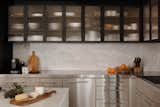 Marble covers the backsplash, and new upper cabinets inset with fluted glass were added.