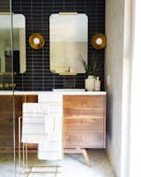 The custom walnut vanity from Northcoast Modern is topped with quartz. A new window brings in more light and a view of the river and trees.