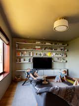 In the den, Vitsoe shelving, a rattan chair by Sika Design, and Hem side tables create a multipurpose space.