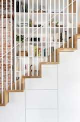 The couple packed storage around the stairs, with cabinets underneath and shelves lining the tread.