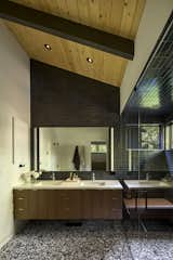 In the main bath, a wall of Heath Ceramics tile joins a terrazzo floor from Ann Sacks.