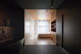 The ceiling and built-in storage wall in the bedroom are fabricated from American white oak, while the opposite wall and floor has the same grayish-white tone found in the rest of the apartment.