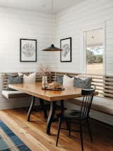 The custom banquette has a slatted back so as to allow the window behind it to open and let in light. The table is a vintage piece from John and Kelly, made with reclaimed wood from a bowling alley. The overhead pendant is by Brendan Ravenhill.