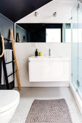 The full bathroom includes Ann Sacks tiles, a wall-hung toilet and a black and white color scheme.