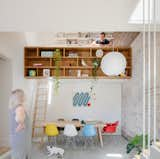 A mezzanine loft level provides extra floor space without increasing the home's footprint. Built-in bookshelves double as a guardrail for the lofted work space, accessed by a built-in ladder.