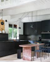 The blush-colored Rojo Alicante marble table in the center of the kitchen doubles as a dining table and kitchen island. A Craiglist score for $200, the table is another kitchen hack conceived by the architects. “It was really a diamond in the rough. Originally, it was a rectangle shape, in a weird ’90s, Italian kind of style, covered in a thick, resin-like finish that made it look almost orange,” says Daniel. The table was honed down to soften its color, and its top was reshaped with rounded corners.