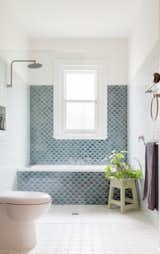 Handmade fish-scale tiles line the wall over the bath.