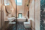 A peek inside the adjoining master bathroom decorated with Marrakesh Design wall tiles, air plants and exposed copper piping.