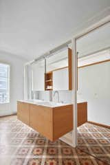 The bathroom furniture and cabinetry are built of oak, while the countertops are made from solid white resin.