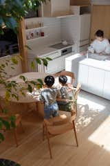 Artificial white marble by Panasonic lines the backsplash and countertops in the kitchen. The open-plan layout lets the wife keep an eye on her children at all times.