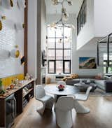 The couple loves to entertain, so it was important that the downstairs living area have a good flow between the kitchen, dining, and living areas. A dramatic chandelier from Lindsey Adelman hangs from the double-height ceiling, punctuating the space. 