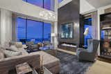 Two story wall of glass overlooking Denver skyline with modern fireplace and custom lighting