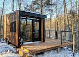 A glass-infill railing allows for uninterrupted views of the surrounding forest.