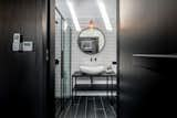 In the bathroom, white tiles punctuate the largely black bathroom, a twist on the house's overall black-and-pine juxtaposition.