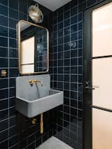 While the rest of the loft is bright and airy, the team wanted to create a moodier look for the powder room. “We used darker handmade tile (Mano from the Cev Series in Cobalt from DDS) and found these concrete sinks from the UK (Elm Sink from Kast Concrete) that can be made any size you want,” Francis says. “We used brass fixtures to finish it off.”