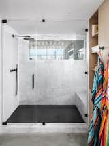 The design team transformed the master bathroom into a luxurious en suite with a white-and-black marble rain shower and multicolored his-and-hers robes from Austin's Hotel San Jose. The team also punched a window through the back wall of the office to allow natural light to permeate the room. “The window is switch glass and can be turned on and off for privacy while in the shower, but still provides a view of downtown.”