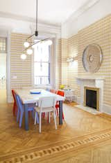 The dining room is for the kids with funky blue and red chairs, gold Ellie Kishimoto wallpaper that is reminiscent of the ornate wallpaper that may existed in this home in the 19th century, and a large table. The fireplace, which is original, was recovered in marble. 