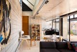 In the living area and kitchen, materials such as concrete and ceramic tiles were chosen for affordability and durability. The angled skylight above the living room provides a void in the slab that could be utilized for a stair or ladder should a third story need to be added in the future.