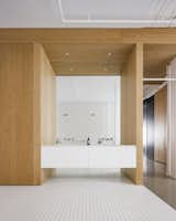 The open bathroom leads directly into the master bedroom. The white tiles give the space an industrial feeling, while the white oak timber joinery brings warmth.