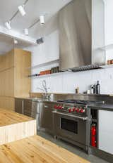 Set in a heritage brick building in Montreal, this apartment maintained the brick wall in the kitchen to evoke the building's industrial heritage. The brick was painted white to brighten the space. 