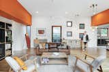 Two dividing orange bulkheads—which are the box gutters that protrudes through the house—separate the three pavilions. The family congregates in the central pavilion for meals around the dining table, and to relax in the lounge.