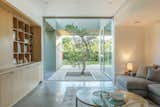 The family room couch is tucked into a nook to create a cozy retreat that still has views past the atrium to the backyard and kitchen.