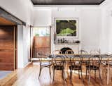 The dining room, which features an original pressed-metal ceiling detail and fireplace, has a large window that opens directly to the sidewalk. The step down from the dining room to the living room represents the junction between the original terrace and the newly built addition. The exposed steel beam running above this junction is also new. "In opening up the house to the courtyard, we had to remove two walls," says Joe. "The steel beams and column support the upper floor of the original house in this area."