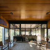 The living space features glazed walls that look out over the garage and through the warehouse-style space toward the library. The couple’s collection of objets d’art are displayed on built-in shelves throughout the home, such as this one that wraps around a fireplace. 