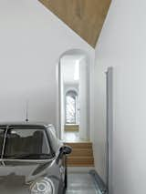 The pitched-roof garage features a four-car stacker, which makes clever use of an existing cellar under the old garage. The arched doorway leads from the garage into the hallway on the first floor.