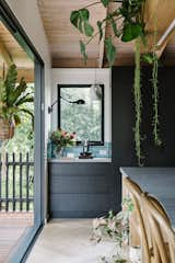 A coffee nook (featuring the same teal-blue tiles as the backsplash) is built into a corner of the kitchen next to the pantry, with a framed view of the eucalyptus trees that surround the home. 