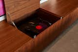 The LP turntable is concealed under a walnut bench, which allows the family to use the space for multiple purposes. When they want to enjoy their extensive record collection, they can simply open up the bench to reveal the record player.  Photo 13 of 17 in This Vacation Home in Rural Ontario Sets a New Standard for Prefab Architecture