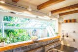 An elongated kitchen window ties the interior to the outdoor deck and bar area and the landscape beyond. 