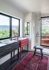 Antique Chinese chests in the main bath flank large glass picture windows.