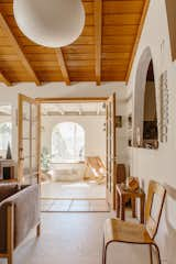 A bent plywood side chair by Thaden-Jordan sits in the primary living area, which opens up to a covered patio.