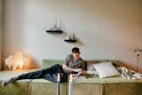 Nick lounging in the living room. The one-of-a-kind candleholder to his right is one of his favorite secondhand finds. "It has these three mirrors which reflect the light of the candle perfectly, and the wiggly shapes are just amazing," he says. 
