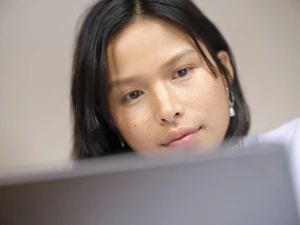 A close-up of a woman looking at a computer.