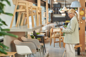 Photo of a female retail store manager using a tablet to review product information.