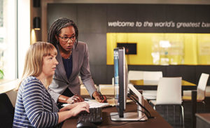 Two women collaborating using a PC.